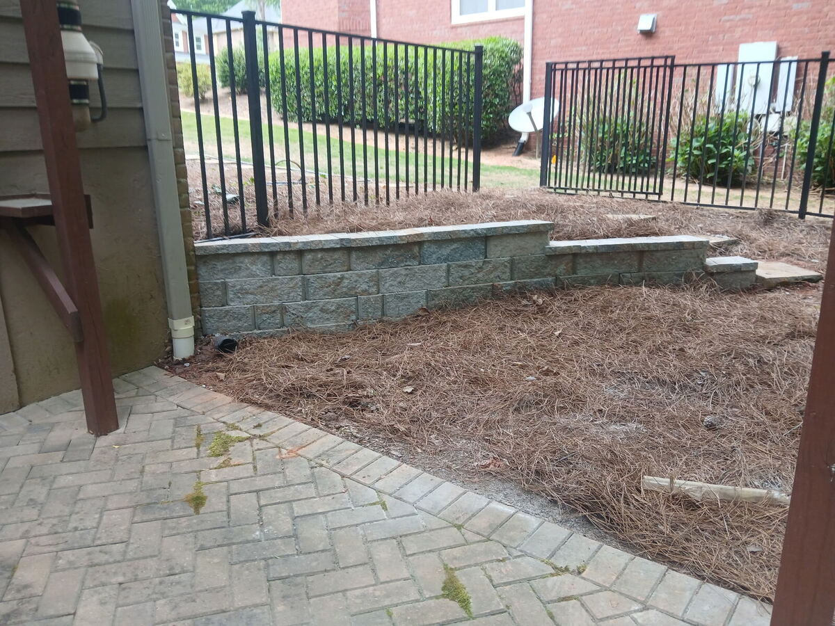 Curved retaining wall integrated with a stone paver patio in Dallas GA