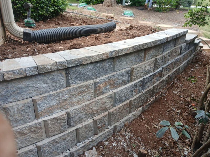 Granite stone retaining wall with capstones following a curve on a West Georgia property