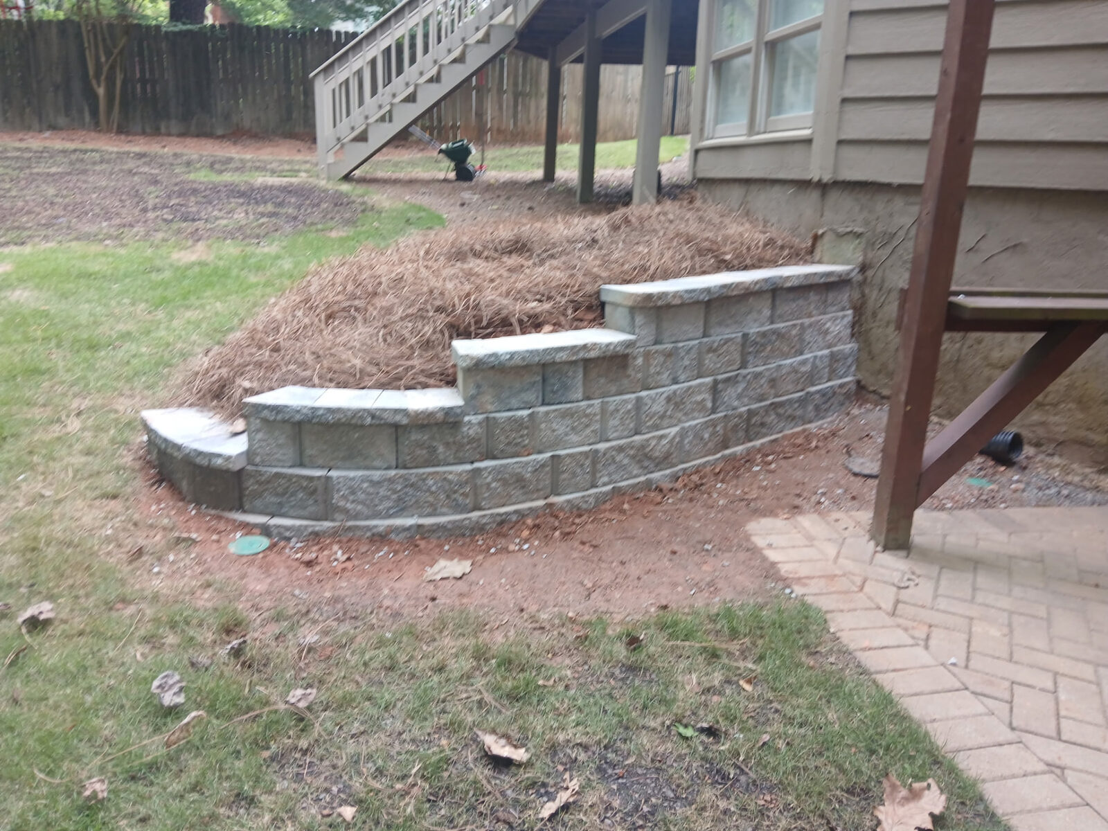 Tiered stepped block retaining wall finished with landscape beds